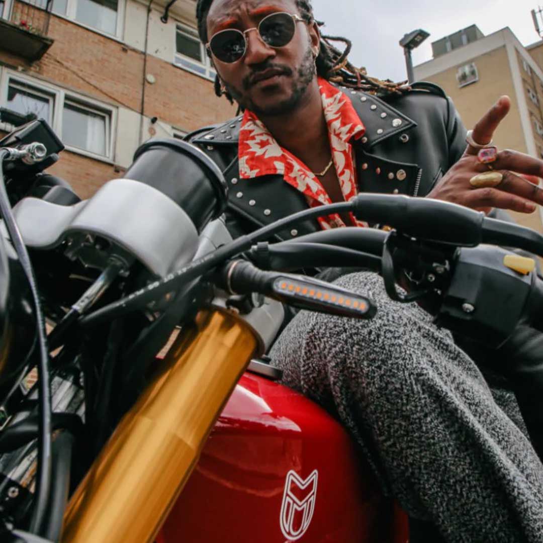 Seye Adelekan posing with the Mutt Motorcycles Gloss Red Razorback 125cc